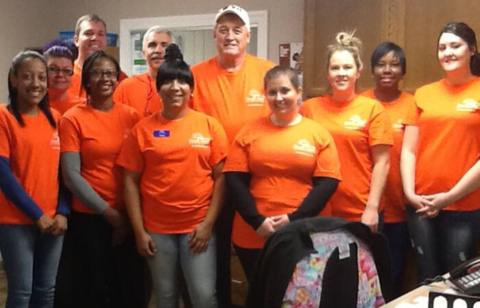Dentists and their team of dental volunteers in orange shirts