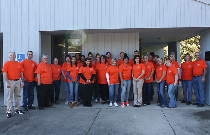 Full volunteer team photo in orange shirts