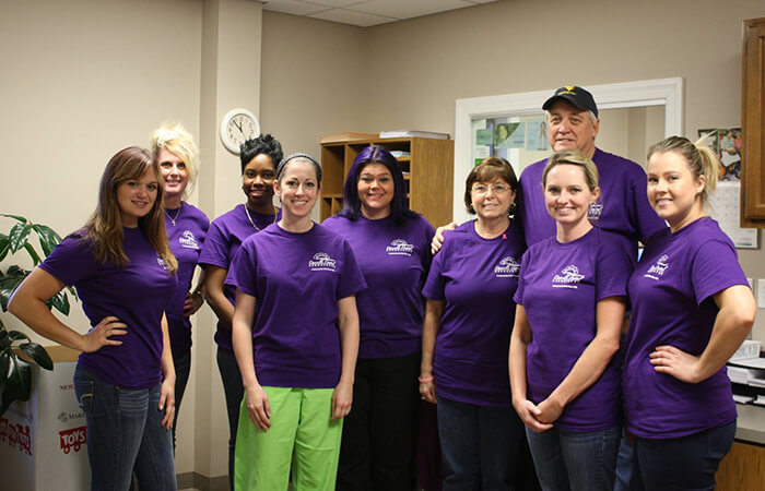 Dr. Evans and his dental volunteers pose in their purple T-shirts